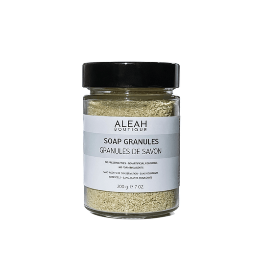 Olive oil soap granules in glass jar with black cap